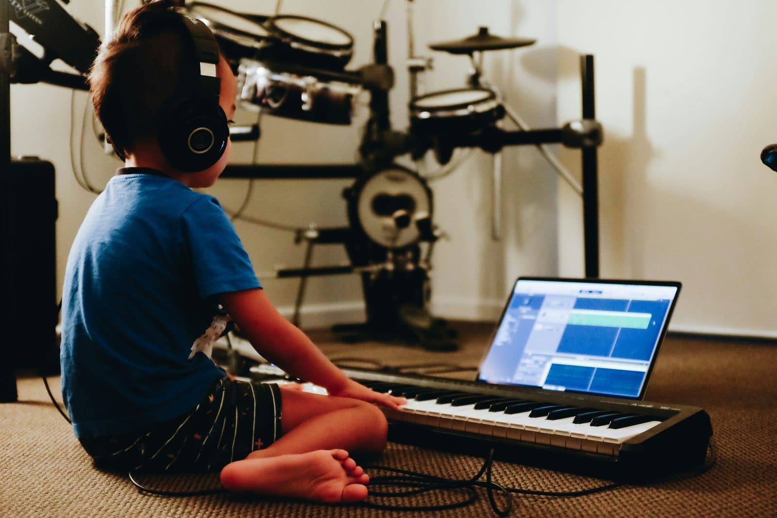 A child learning music with a keyboard and digital tools