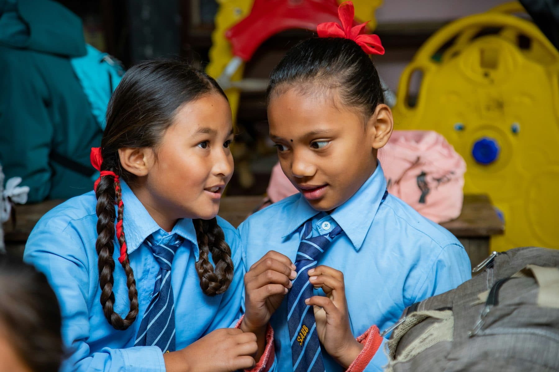 Two Nepali schoolgirls talking together in class